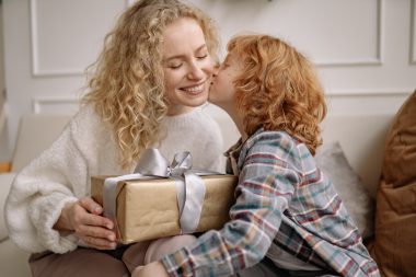 boy giving a gift to mom