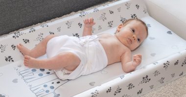 baby lying on a diaper changing pad