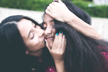 mom kissing her daughter