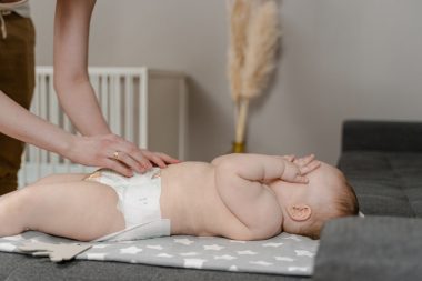 mother changing baby diaper