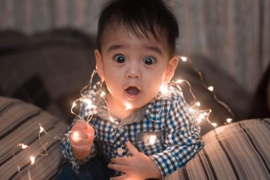 little boy playing with chirstmas lights