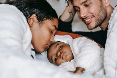 mom kissing sleeping baby's forehead