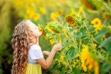 girl smelling sunflower